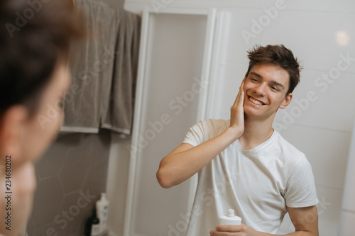 man putting after shave lotion on his face photo