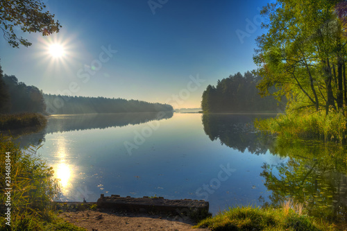 Fototapeta Naklejka Na Ścianę i Meble -  The sun illuminates the surface of the lake. Masuria, Poland.