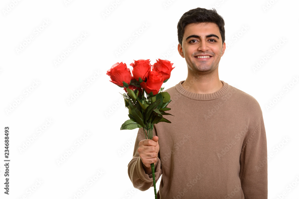 Young happy Persian man holding red roses ready for Valentine's Young happy Persian man holding red roses ready for Valentine's