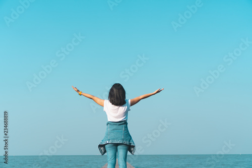 Woman rise hands up to sky freedom concept with blue sky. © ant