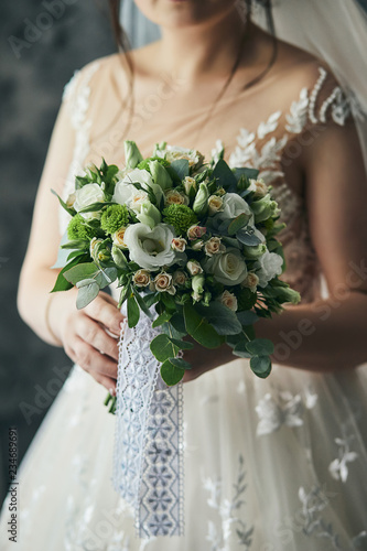 bouquet in hands of the bride, woman getting ready before wedding ceremony