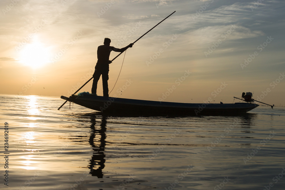 Silhouette of man with sunrise sky background, livelihoods of fishermen in Thailand