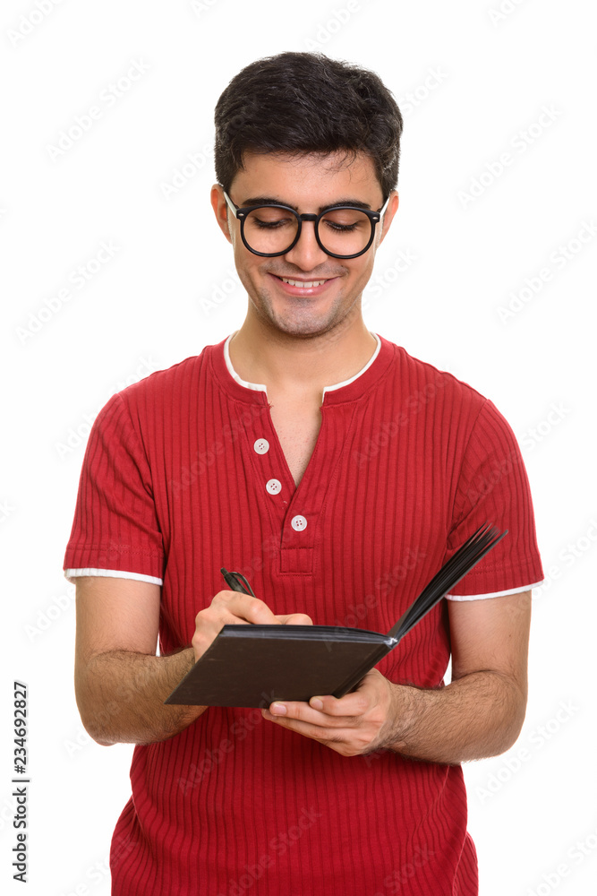 Young happy Persian man writing on diary Young happy Persian man writing on diary