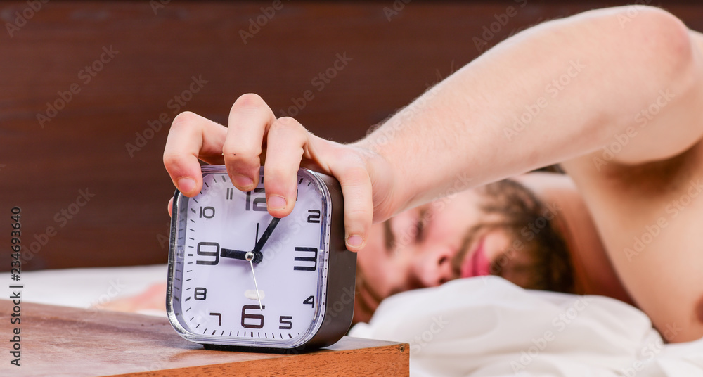 Foto de Lazy man happy waking up in the bed rising hands in the morning ...