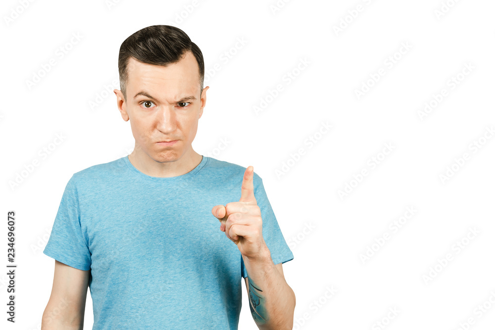 Portrait of young sullen guy with index finger up isolated on a white background. Portrait of young sullen guy with index finger up isolated on a white background.