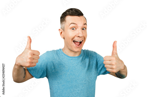 Portrait of young smiling guy showing thumbs up isolated on a white background. © vika33