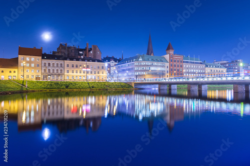 Night city mirrored in the water. Evening panorama of an old European town. Cityscape of Malmo  Sweden