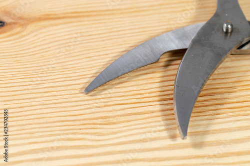 Close up of a silver scissors in the kitchen on a wooden table