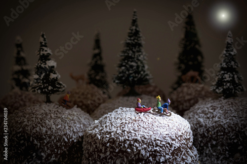 Kinder fahren Schlitten auf einem Schoko Kokos Schaumkuss  photo