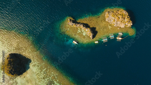 Aerial view: beach, tropical island, sea bay and lagoon, Palawan. Lagoon with blue, azure water in the middle of small islands and rocks. Busuanga. Seascape, tropical landscape. Philippines.