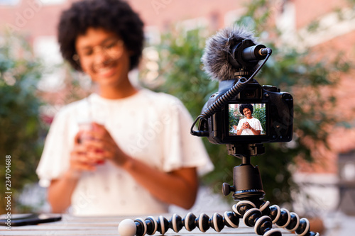 Woman recording a video content while sitting in outdoor cafe photo