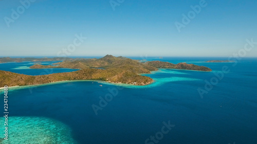 Aerial view: Lagoon with blue, azure water in the middle of small islands and rocks, Palawan. Beach, tropical island, sea bay and lagoon, mountains with forest, Coron. Busuanga. Seascape, tropical