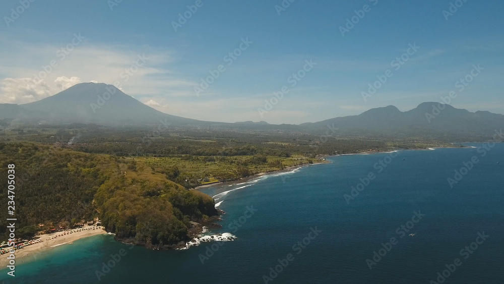 Aerial view of tropical beach with palm trees on the island Bali, Indonesia. Seascape: ocean, sky, sea, virgin beach. Travel concept.
