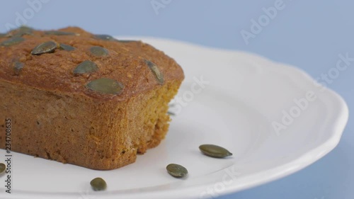 Gluten-Free pumpkin bread with pumpkin seed in white plate set on light blue background. photo