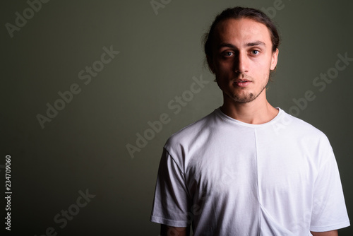 Young handsome man wearing white shirt against colored backgroun