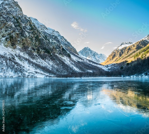 Panoramic landscape  frozen mountain Baduk lake and mountain range with reflection on ice  national park in Caucasus mountains  Russia