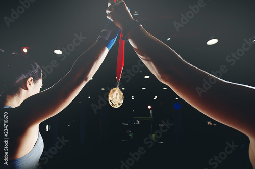 MMA holds up her hand with gold medal photo