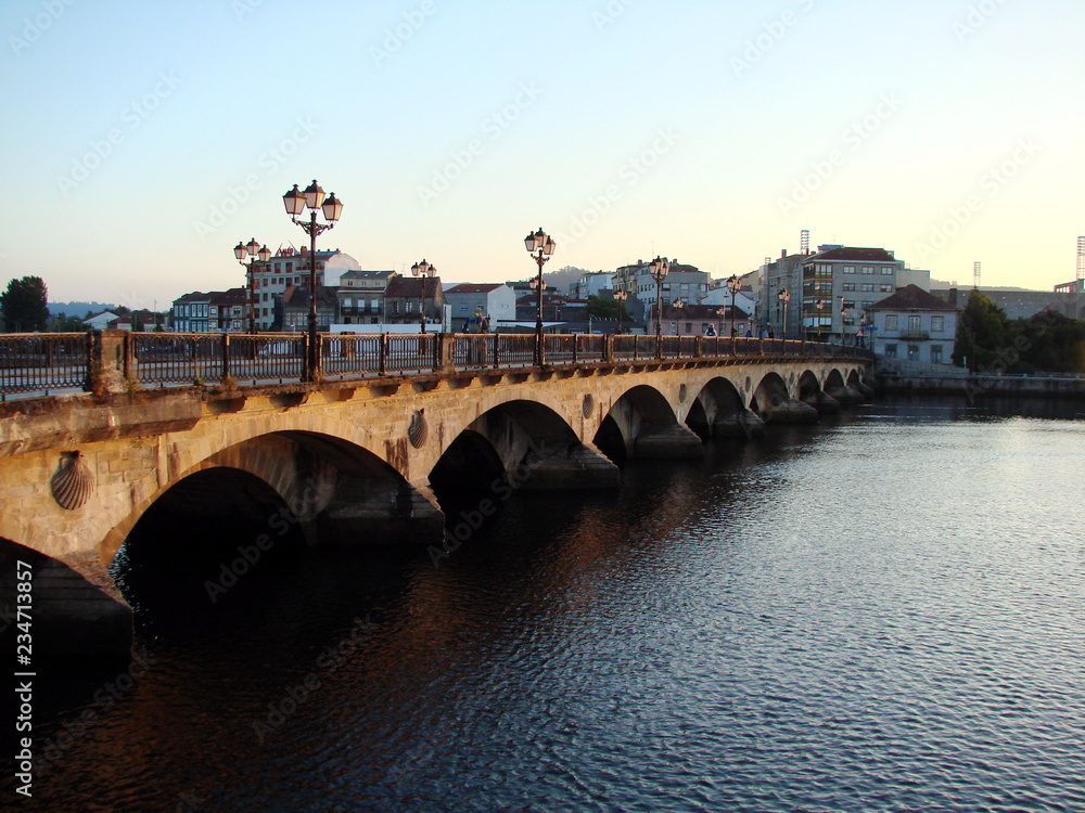 Obraz premium Early awakening of the streets and bridges of a small town against the backdrop of a variety of rainbow colors of the sunrise.