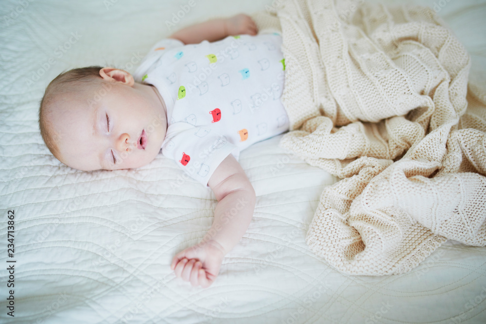 Baby girl sleeping under knitted blanket Baby girl sleeping under knitted blanket