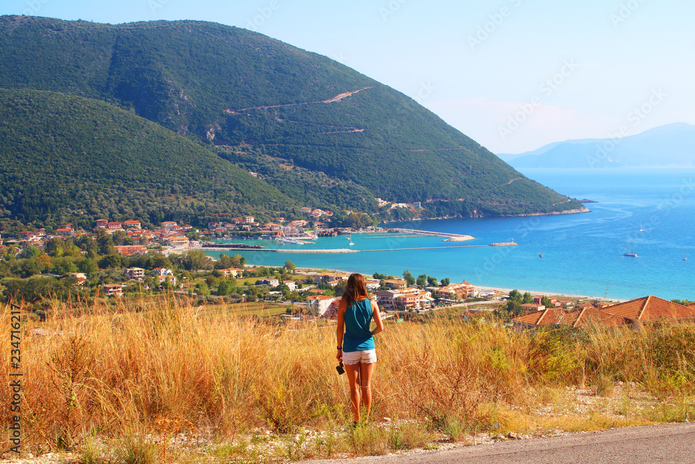 Tourist enjoying the lovely view at Vassiliki Bay on Lefkada Island, Greece