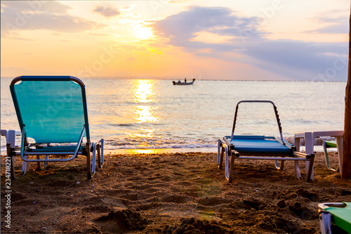 Morning Sun over sea, dawn, deck chairs are placed next to the coastline