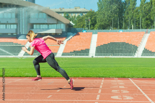 A young girl in the stadium runs.