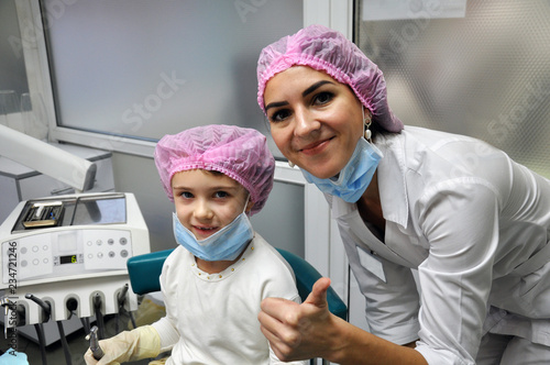 little girl and dentist doctor smile after dental treatment procedure.