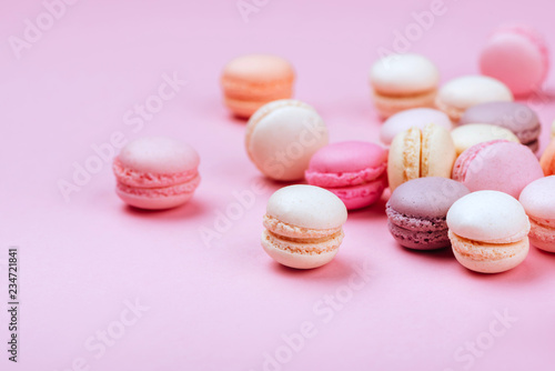 Different types of macaroons on pink background. Sweet and colourful french macaroons.