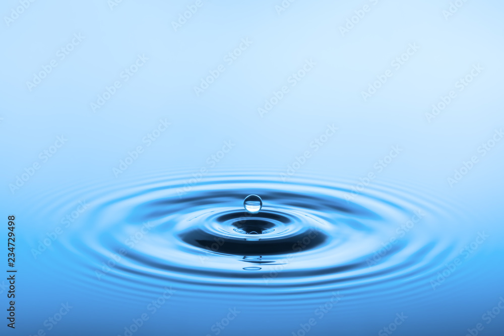 Wassertropfen über blauer Wasseroberfläche Wassertropfen über blauer Wasseroberfläche