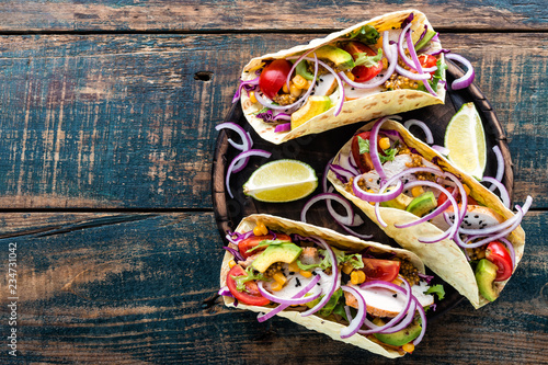 Mexican tacos with chicken meat, vegetables and fresh greens