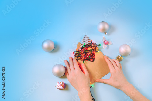 Christmas composition. Christmas decorations and craft envelope with fiery garland on a blue background. Flat top view