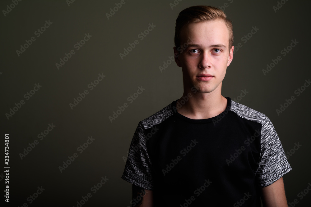 Fototapeta premium Young handsome man with blond hair against colored background
