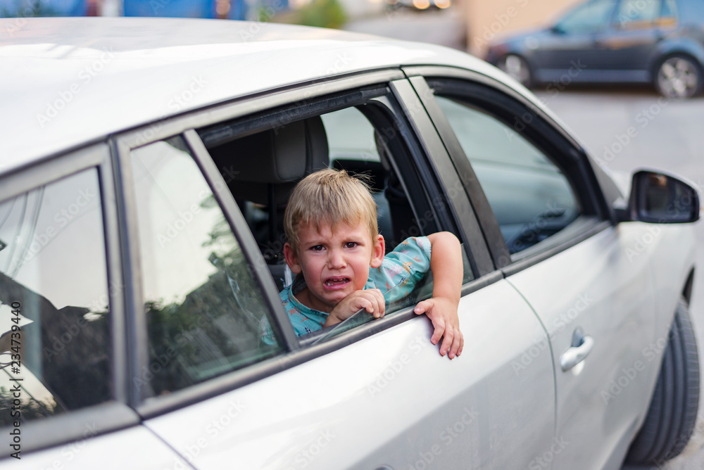 child separated from one parent leaving in a car, sad and crying child separated from one parent leaving in a car, sad and crying