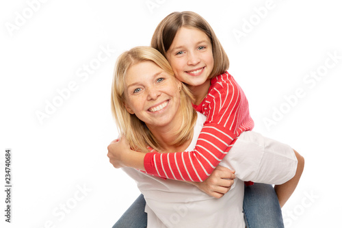 Mom with her teenage daughter hugging and laughing, white background