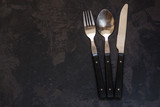 set of cutlery fork, spoon, knife (vintage). Black background. Top view . Copy space.