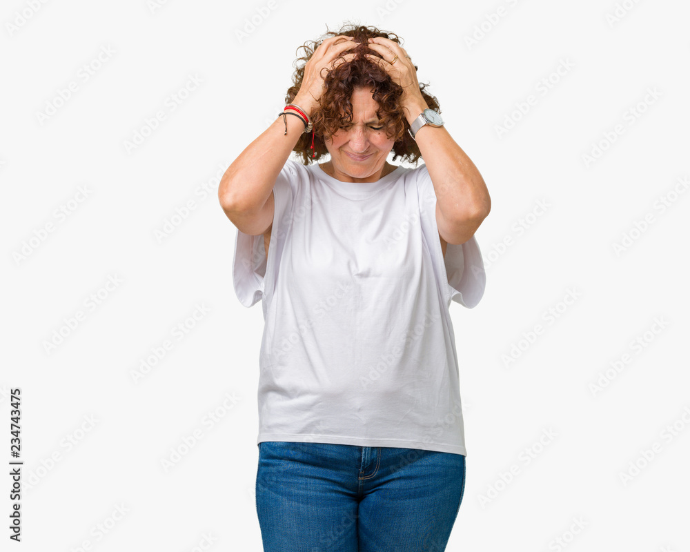 Beautiful middle ager senior woman wearing white t-shirt over isolated background suffering from headache desperate and stressed because pain and migraine. Hands on head. Beautiful middle ager senior woman wearing white t-shirt over isolated background suffering from headache desperate and stressed because pain and migraine. Hands on head.