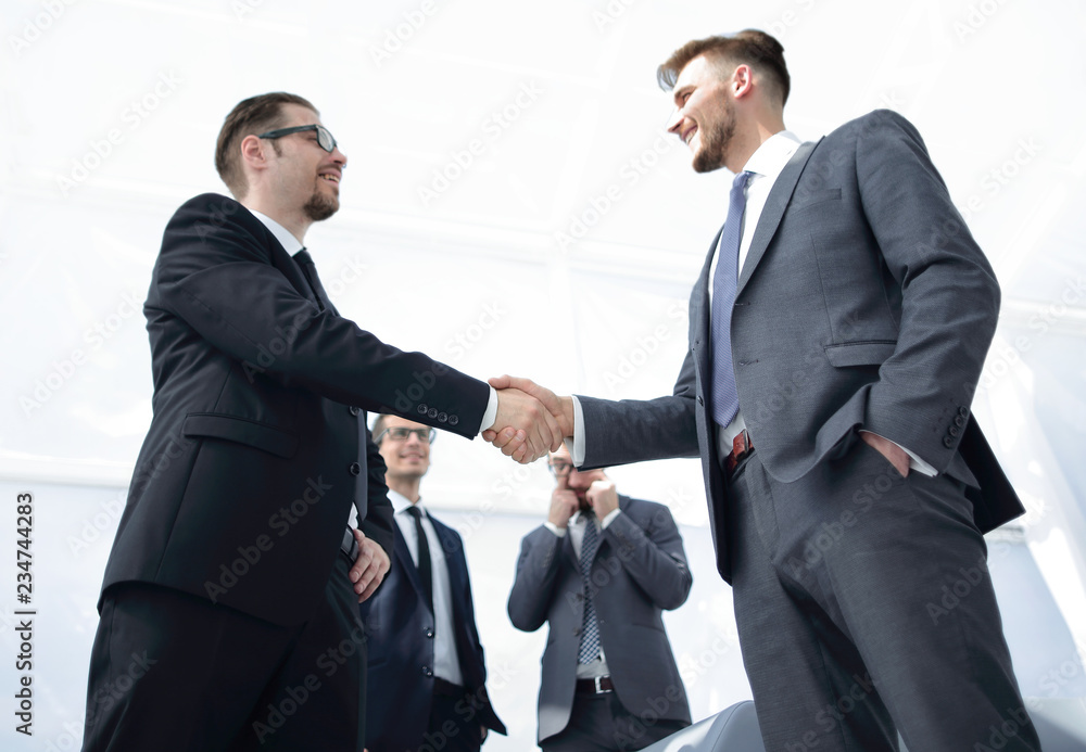 bottom view.smiling business people shaking hands bottom view.smiling business people shaking hands
