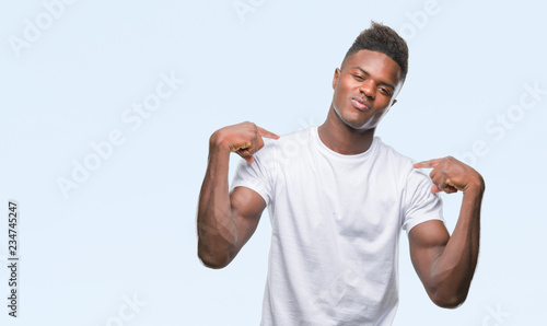 Young african american man over isolated background looking confident with smile on face, pointing oneself with fingers proud and happy. © Krakenimages.com