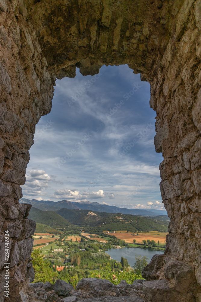 Beautiful lake Piediluco view and the ancient town Labro on the hill from the window of an old ruined castle (Rocca di Piediluco). Terni, Umbria, Italy