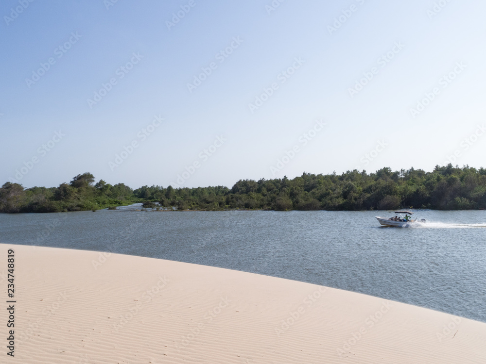 Amazing view of a Brazilian mangrove, white dune, forest and a boat sailing, Brazil, Parnaíba. 