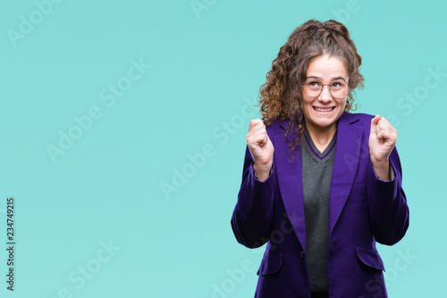 Young brunette student girl wearing school uniform and glasses over isolated background excited for success with arms raised celebrating victory smiling. Winner concept. © Krakenimages.com