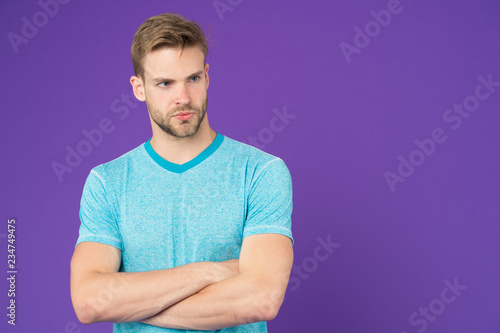 Man strict handsome unshaven guy on violet background. Masculinity concept. Man with muscular arms confident and strong. Does having muscular body make you more confident. Strong and muscular