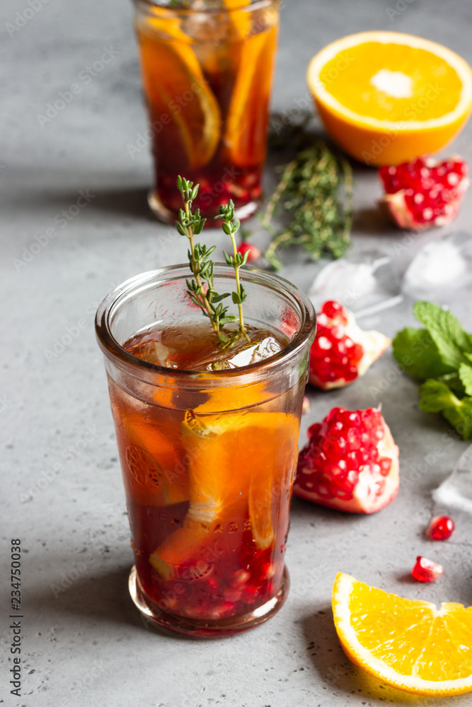 Cold lemonade or festive cocktail with pomegranate, mint and orange. Grey concrete background. Copy space. Cold lemonade or festive cocktail with pomegranate, mint and orange. Grey concrete background. Copy space.