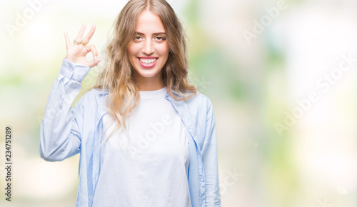 Beautiful young blonde woman over isolated background smiling positive doing ok sign with hand and fingers. Successful expression.