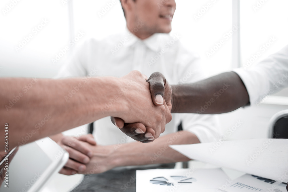 close up.handshake business partners sitting at the Desk