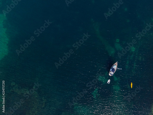 White sailing ship yacht at sea in shallow water near shore. Aerial drone view of sailboat. View from above.