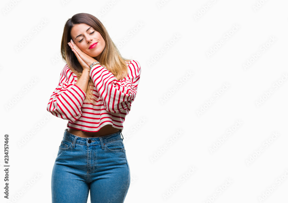 Fototapeta premium Young beautiful woman casual stripes winter sweater over isolated background sleeping tired dreaming and posing with hands together while smiling with closed eyes.
