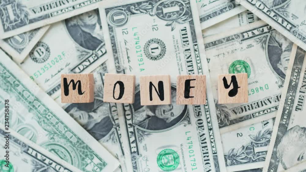 rotating word money from wooden letters, on dollars, concept rotating word money from wooden letters, on dollars, concept
