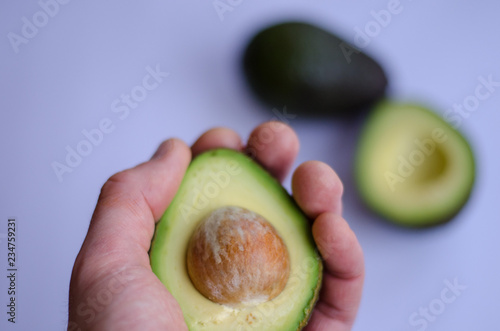 Avocado in hand on white background