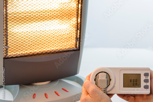 Medidor de consumo eléctrico conectado a una estufa halógena photo
